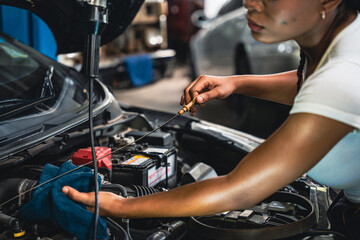 Mechanic using a cloth to clean the dipstick in the garage.