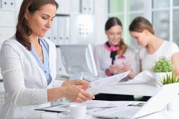 young women sit at the table and work in a modern office