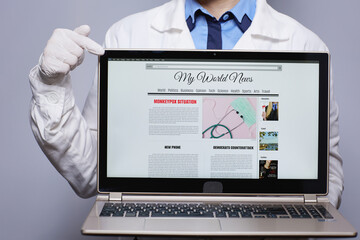 Modern female medical doctor showing laptop with monkeypox news