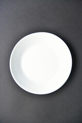 White empty plate on a black background. From a white plate to a black one.