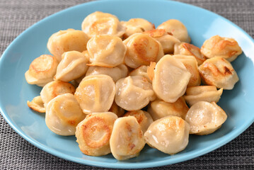 Fried dumplings on a blue plate.