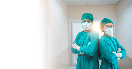 Portrait Two confidence doctor wear protective scrubs suit with glove,medical mask stand in arms crossed in hospital corridor,hallway. Professional team surgeons. Healthcare,Hospital emergency concept