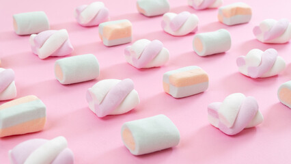 Marshmallow lined up diagonally - pink background with sweets