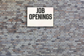 job openings written on brick wall with light box 