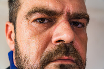 Portrait of man looking into lens seriously.