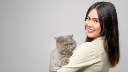 A young woman is holding lovely cat , playing with cat in studio on white background