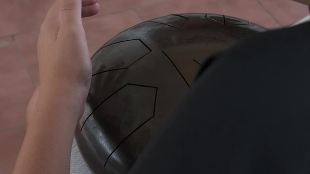 the boy plays a small handpan