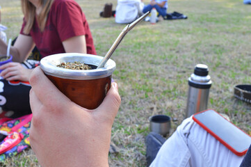 student drinking Argentine brown mate in a park
