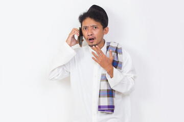 shock and confused asian muslim man using mobile phone isolated on white background