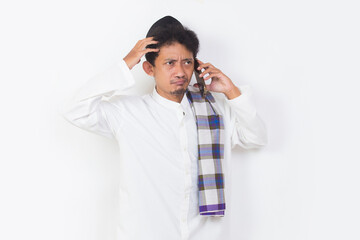shock and confused asian muslim man using mobile phone isolated on white background