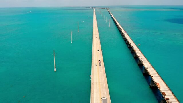 Old Seven Mile Bridge. Drone view of a low-water bridge across the ocean with moving cars. Active movement of vehicles in both directions. A truck on a bridge in the middle of the ocean.