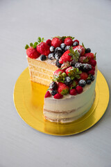 Naked cake with berries Birthday cake covered with american buttercream and cake topper