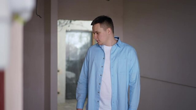 Thoughtful focused Caucasian man looking around standing in new flat pointing talking. Confident concentrated apartment owner planning renovation and repair indoors. Real estate ownership concept