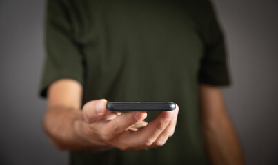 Caucasian man holding smartphone at home.