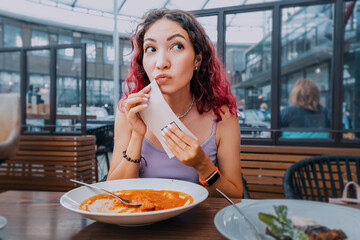 The girl observes tact and good manners and wipes her mouth after a hearty meal in a cafe. First Date and Eating Behavior