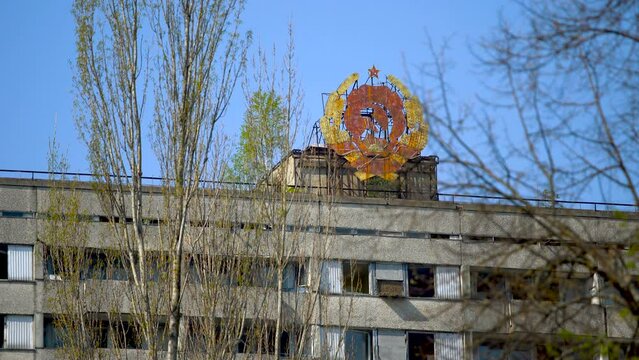 The State Emblem of the USSR on an old abandoned building in the city of Pripyat. Chernobyl exclusion zone. Ukraine