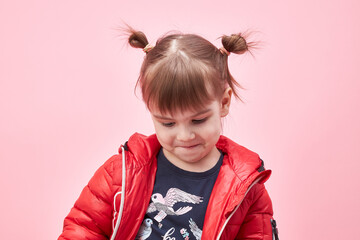 a child in a jacket on a pink background.