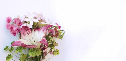 Delicate pink lilies and roses on a white background. Festive flower arrangement. Background for a greeting card.