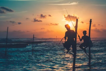 Foto op Aluminium Sri Lanka two local fisherman silhouettes at the sunset sea. Traditional fishermen fishing on stick - famous tourist attraction. Impressive bright colorful seascape. Travel, adventure, concept image. © Anastasia Pro