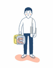 ペットキャリーに入った犬を運ぶ若い男性