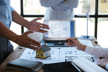 Close up of hands working and brainstorming on paperworks and floor plan drawings about design architectural and engineering for houses and buildings.