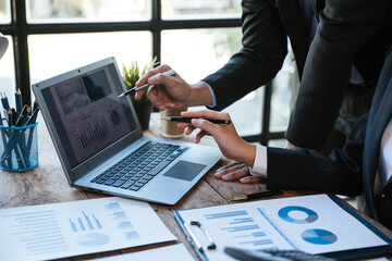 Close up of hands are working and brainstorming on laptop paperworks about business financial and...