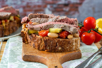 Beef steak on sourdough with garlicky tomatoes, courgettes and cannellini beans