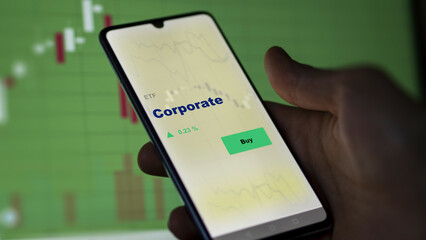 An investor's analyzing the corporate etf fund on screen. A phone shows the corpo ETF's stock to invest