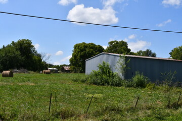 Fototapeta na wymiar Metal Barn in a Farm Field
