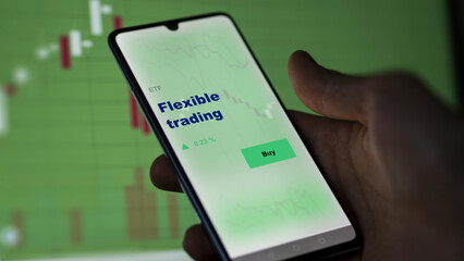 An investor's analyzing the flexible trading etf fund on screen. A phone shows the ETF's prices flexible trading to invest