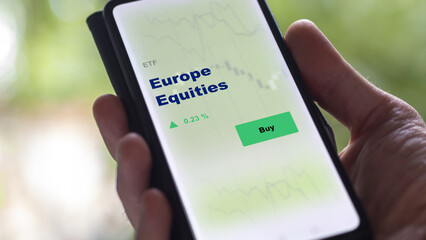 An investor's analyzing the europe equities etf fund on screen. A phone shows the ETF's prices...