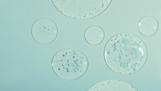 Top view of liquid cosmetics gel with bubbly structure on pastel cyan background,large banner.