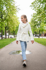 little beautiful girl with long blond hair having fun in the green park on sunny spring day