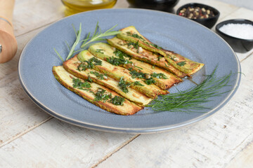 Fried zucchini on plate over wooden background with free text space. Top view