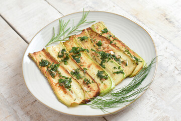 Fried zucchini on plate over wooden background with free text space. Top view