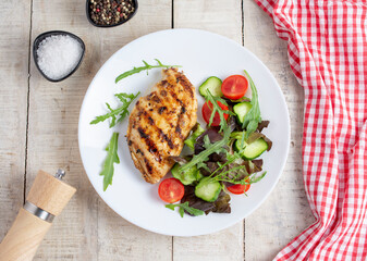 Grilled chicken breast. Fried chicken fillet and fresh vegetable salad of tomatoes, cucumbers and...