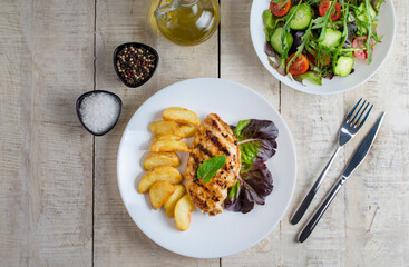 Grilled chicken breast, fillet, steak and fresh vegetable salad, top view. Healthy keto, ketogenic lunch menu with chicken meat and organic veggies and greens. Wooden table. Flat lay
