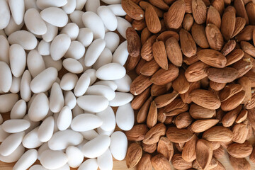 
Close-up of white coated candied almonds and almond kernels