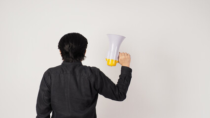 The man is turn around and hand is holding a megaphone and wearing a black shirt on white background. Shrink the arms