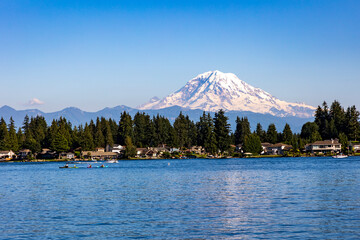 kayakers on blue colored water of Lake Tapps with snow capped Mt. Rainier on the background.
