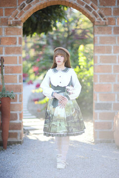 A beautiful woman in lolita dress in garden background Japanese street fashion portrait
