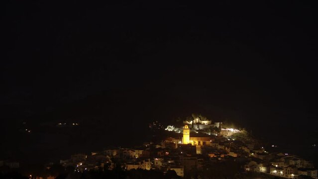 Night view of small town on the hill Polop, Spain