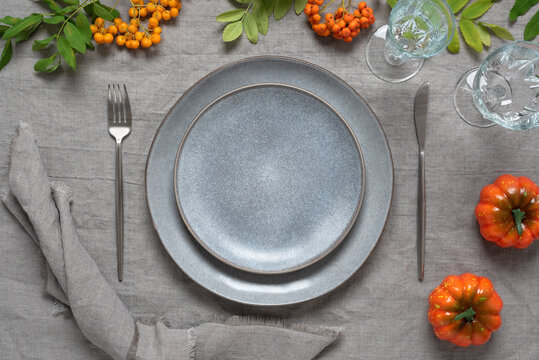 Autumn Table Setting With Empty Plate Mockup. Gray Linen Texture Background. Serving For Thanksgiving Day With Pumpkins And Rowan Berries. View From Above, Copy Space, Selective Focus.