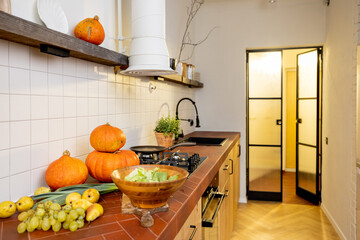 Fresh vegetables and pumpkins on table in kitchen