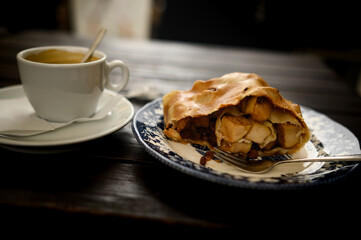 juicy apple pie and a cup of coffee on a table in a cafe. Apple strudel