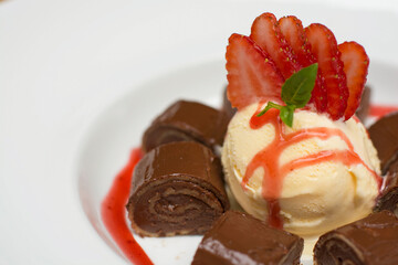Chocolate pancakes crepe with ice cream and strawberries