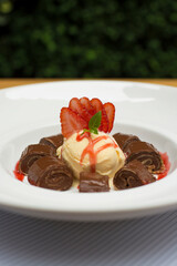 Chocolate pancakes crepe with ice cream and strawberries