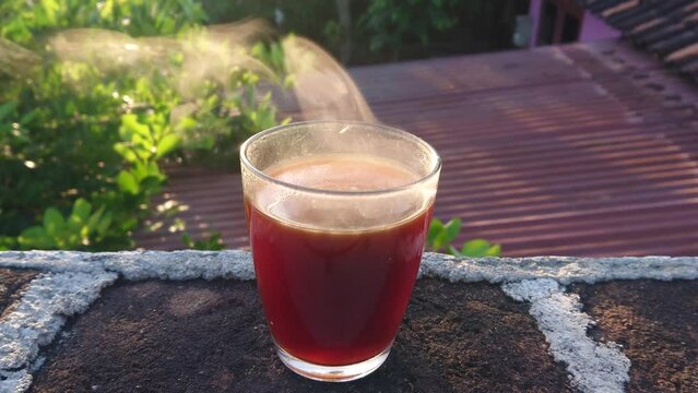 a cup of hot and smoky black coffee on a sunny morning