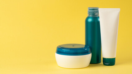 Cosmetics for skin and hair care on a yellow bright background, space for text and labels