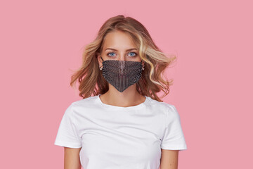 A young attractive woman in a white casual t-shirt wears  a stylish fashionable protective face...